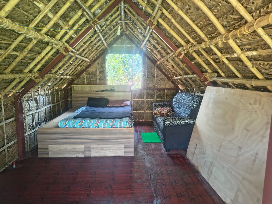 Bamboo eco house interior — bed and woven bamboo walls